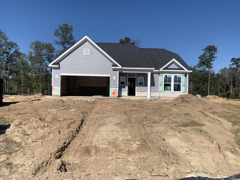 View of front facade featuring covered porch, driveway, and a shingled roof