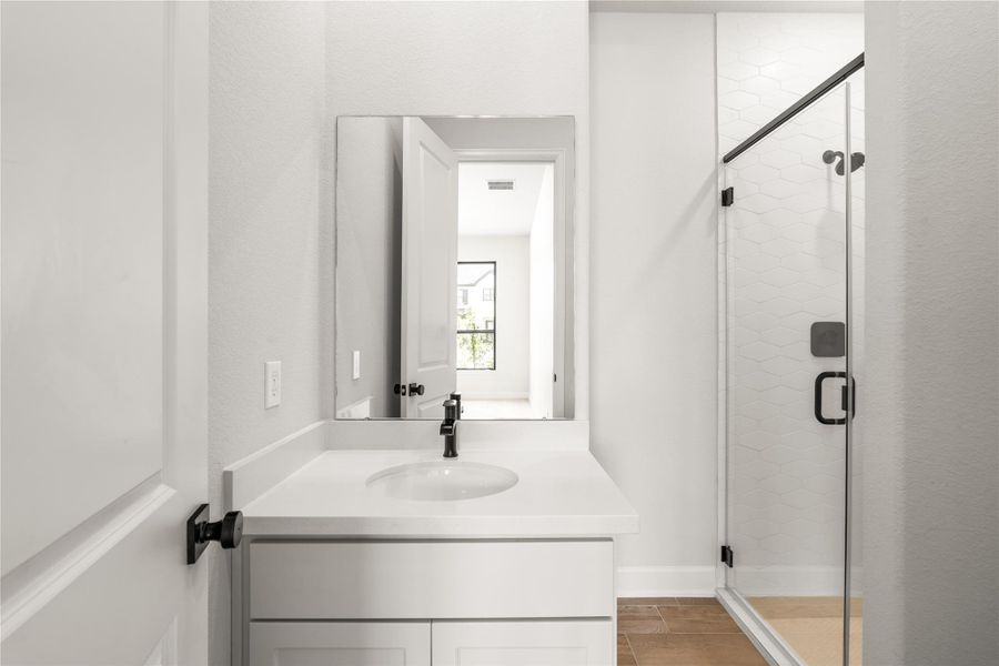 Modern bathroom featuring a sleek vanity, elegant fixtures, and a spacious glass-enclosed shower.