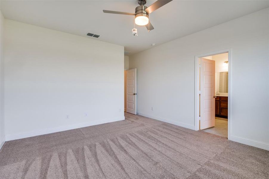 Empty room with light carpet and a ceiling fan