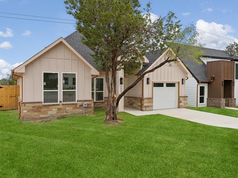 Modern farmhouse featuring a front yard and a garage