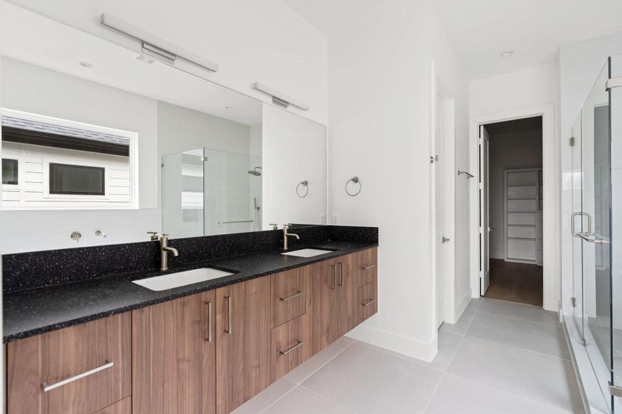 His-and-hers vanity areas with quartz countertops, high-end Moen plumbing fixtures, and cabinetry by GoBravura. His-and-hers vanity areas with quartz countertops, high-end Moen plumbing fixtures, and cabinetry by GoBravura.