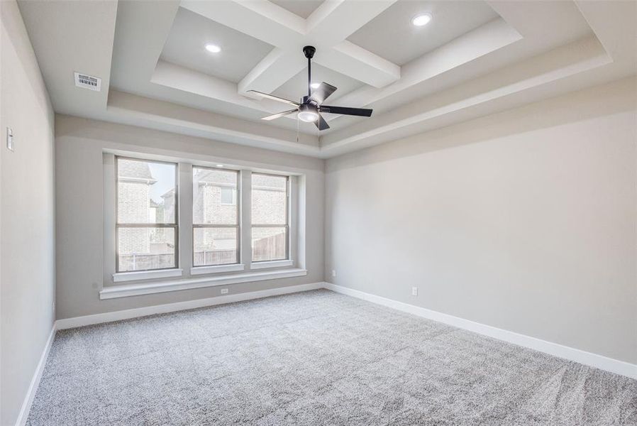 Master bedroom featuring coffered ceiling, recessed lighting, ceiling fan, beam ceiling, and a tray ceiling