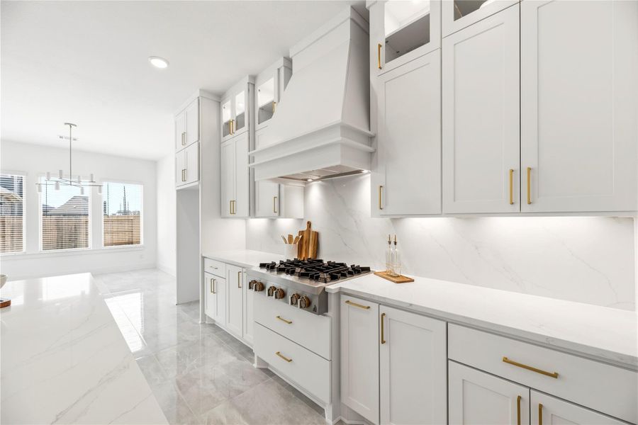Elevate your culinary experience with this custom-designed cook space, featuring a professional-grade gas range , quartz backsplashes , and elegant under-cabinet lighting  that highlights the refined finishes.