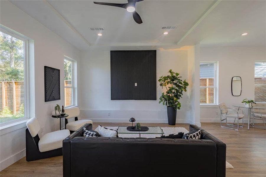 Living area featuring wood finished floors, a ceiling fan, recessed lighting, a raised ceiling and a breakfast nook Living area featuring wood finished floors, a ceiling fan, recessed lighting, a raised ceiling and a breakfast nook