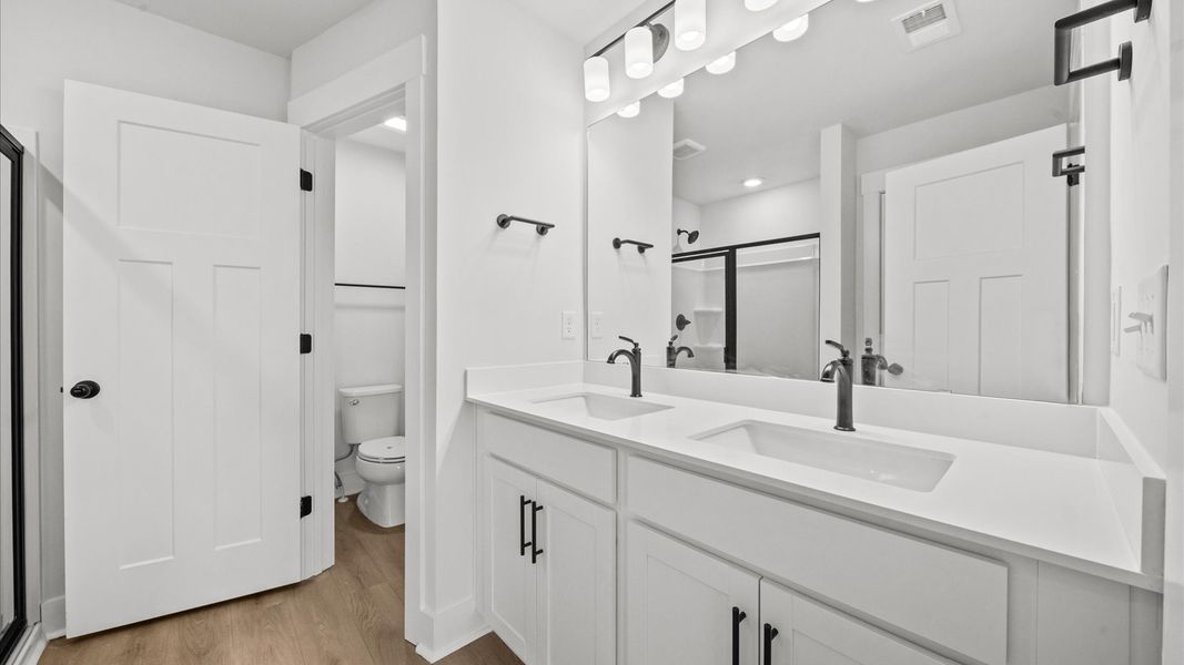 Superior en-suite primary bathroom with stylish dual vanity and walk-in shower crafted with high standards in mind