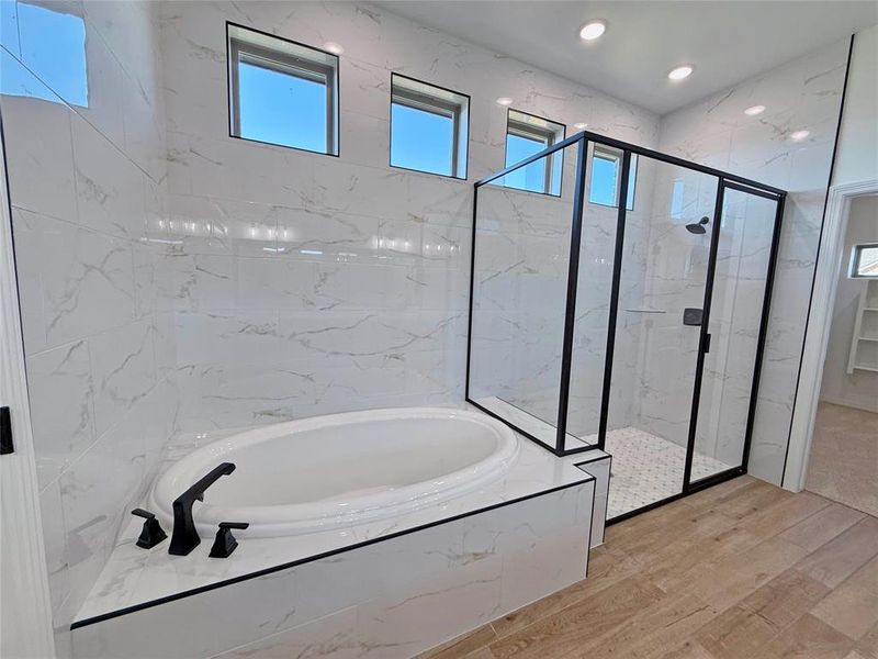 Bathroom with a marble finish shower, a bath, recessed lighting, and wood finished floors