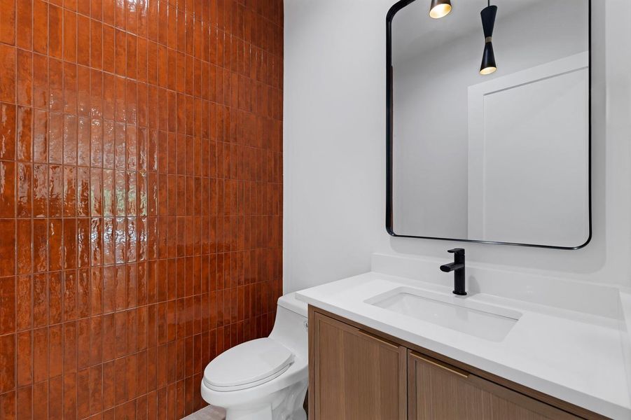 Half bath featuring vanity and toilet Half bath featuring vanity and toilet