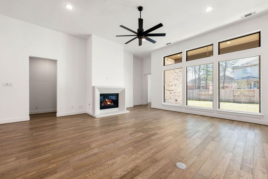 Gather the family and guests together in your lovely living room! Featuring high ceilings, recessed lighting, dark stained ceiling fan, custom paint, gorgeous floors, and large windows that provide plenty of natural lighting throughout the day!