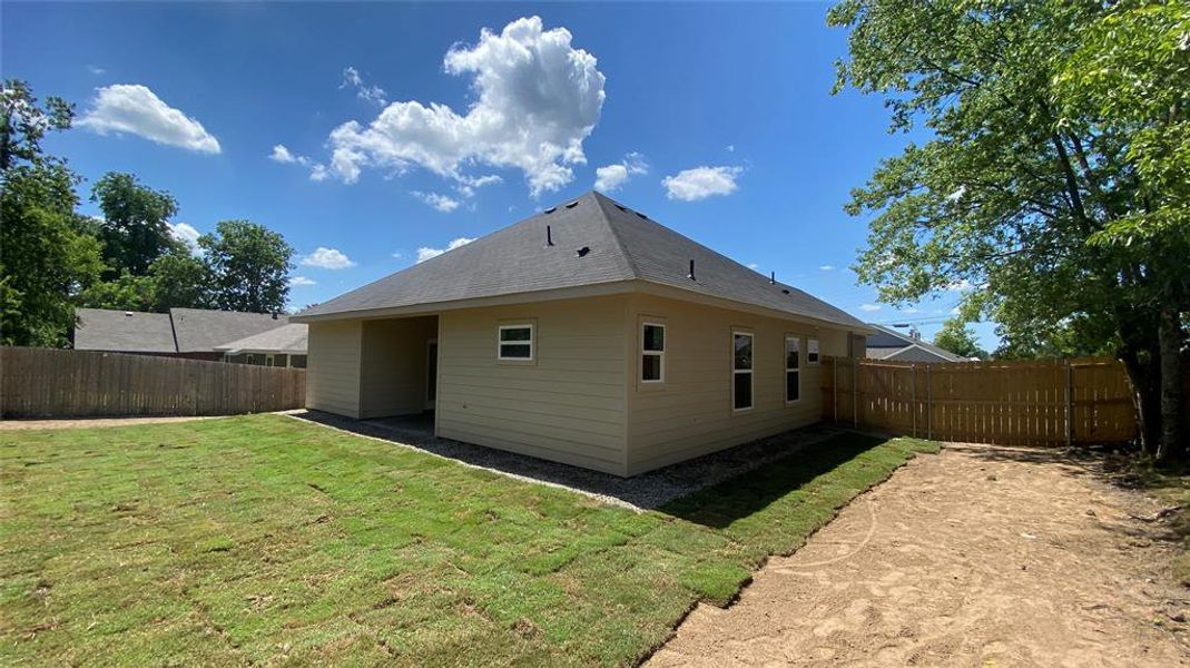 Back of house with a lawn