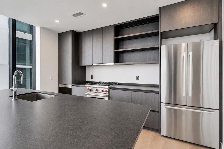 Sleek dark cabinetry and stone countertops anchor this modern kitchen space. Sleek dark cabinetry and stone countertops anchor this modern kitchen space.