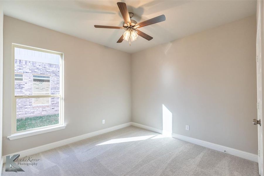 Spare room with light carpet and a ceiling fan