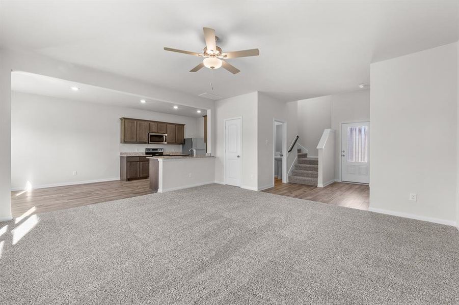 Unfurnished living room with ceiling fan and light hardwood / wood-style flooring