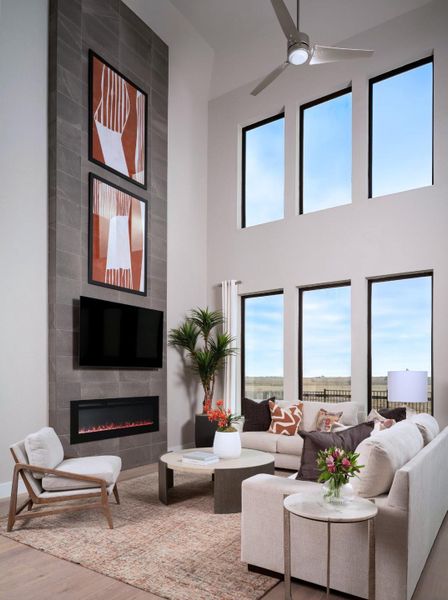 Living area featuring a fireplace, wood finished floors, plenty of natural light, and ceiling fan
