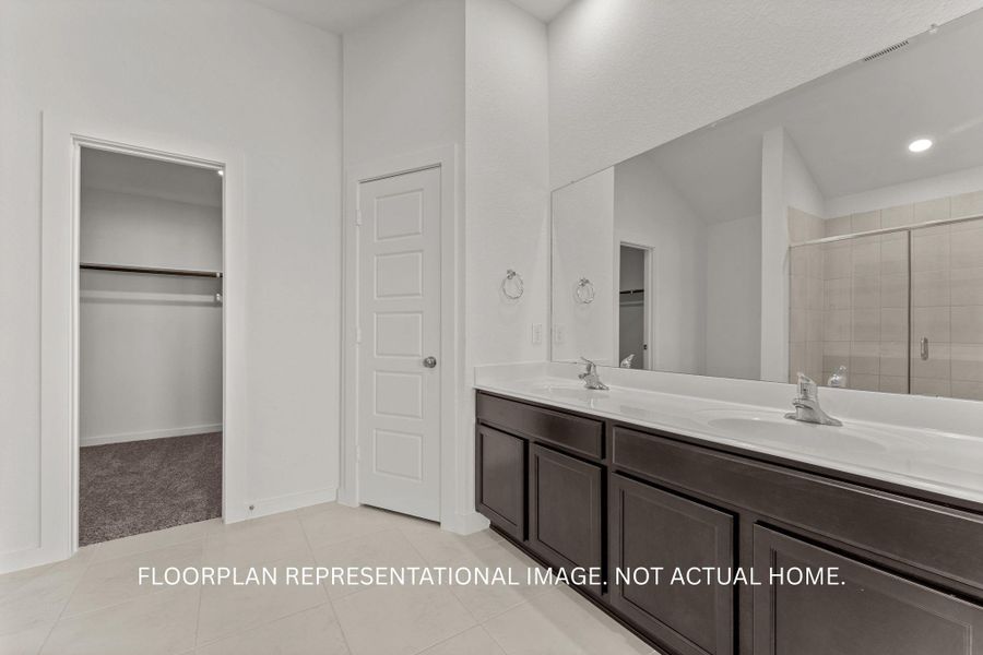Double vanity sinks and an ample mirror define this well-appointed primary bathroom, offering both comfort and functionality.