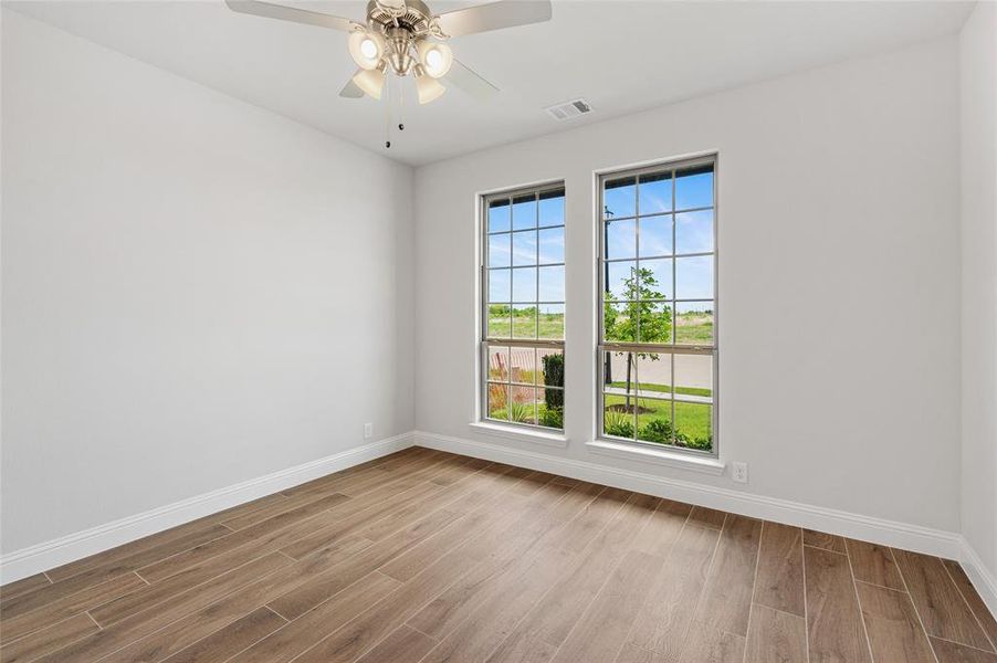 Empty room with light wood-type flooring and ceiling fan