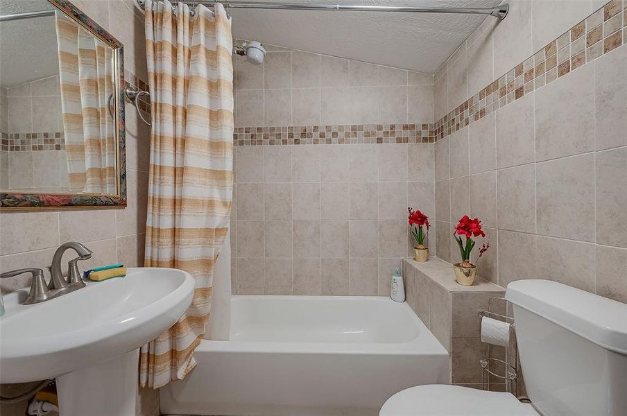 The bathroom is equipped with a bathtub, sink, and toilet, offering essential amenities for comfort and convenience.