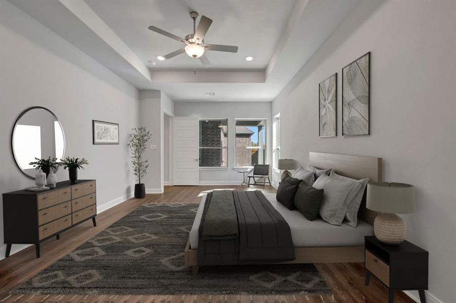 Bedroom with dark wood finished floors, a ceiling fan, a tray ceiling, and recessed lighting