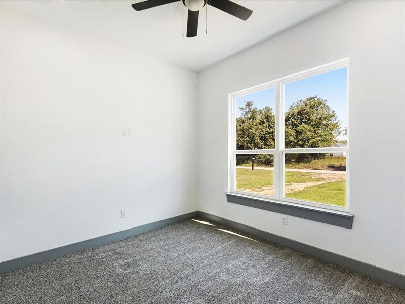 Empty room featuring dark carpet and ceiling fan Empty room featuring dark carpet and ceiling fan