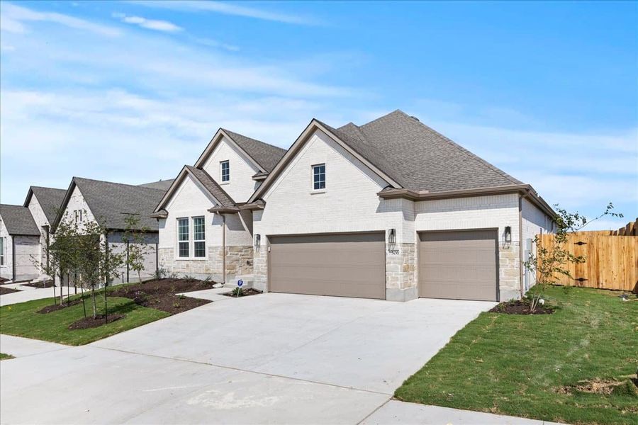 Front exterior of a new home in Sunfield, Buda, TX, highlighting curb appeal (Image 21). Front exterior of a new home in Sunfield, Buda, TX, highlighting curb appeal (Image 21).