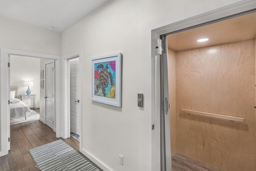 Corridor featuring dark wood-style flooring, elevator, and recessed lighting Corridor featuring dark wood-style flooring, elevator, and recessed lighting