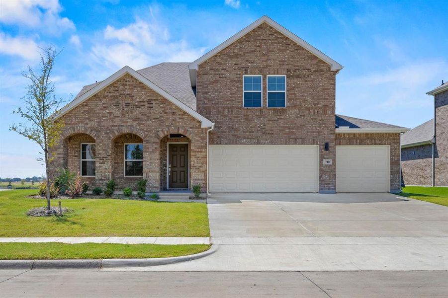 Front exterior of a new home in The Estates Collection at Overland Grove, Forney, TX, highlighting curb appeal (Image 14).