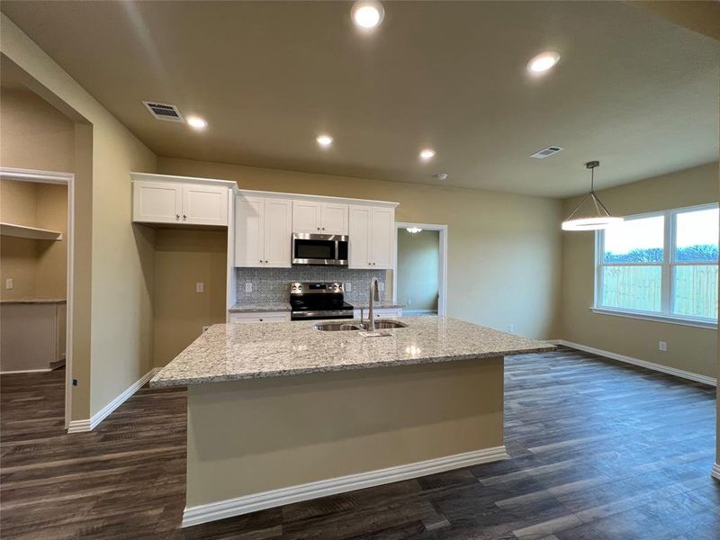 Kitchen with Island Seating, Granite Countertops, Soft-Close Shaker Cabinets, Stainless Steel Appliances and Dining Area