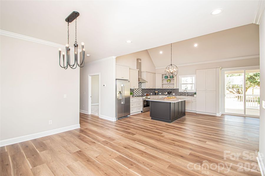 Bright and spacious dining room with elegant chandelier and oversized window providing plenty of natural light.