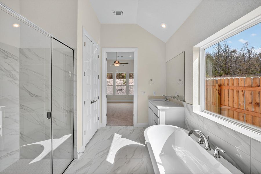 Full bath featuring a soaking tub, vanity, lofted ceiling, recessed lighting, and ceiling fan Full bath featuring a soaking tub, vanity, lofted ceiling, recessed lighting, and ceiling fan