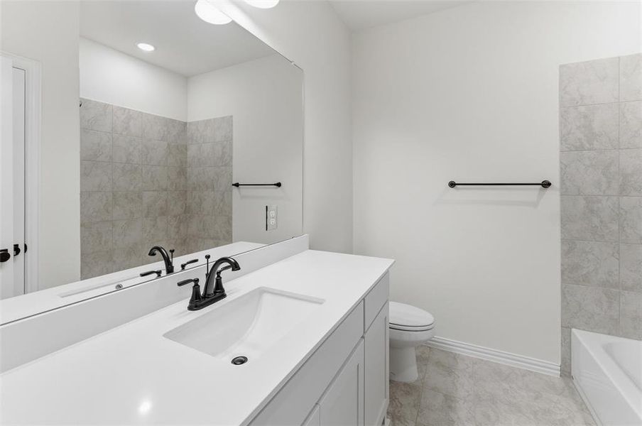 Bathroom vanity with an integrated sink, black faucet, and a large wall-mounted mirror