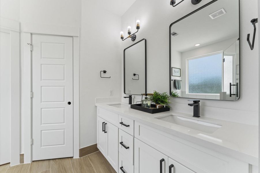 Indulge in everyday luxury in this elegant primary bathroom, where a freestanding soaking tub and a spacious walk-in shower offer the best of both worlds. The frameless glass shower enclosure beautiful tilework, while the tub invites relaxation. A double vanity with quartz countertops and individual mirrors adds modern sophistication, and soft neutral tones create a serene, spa-like ambiance that elevates your daily routine. Indulge in everyday luxury in this elegant primary bathroom, where a freestanding soaking tub and a spacious walk-in shower offer the best of both worlds. The frameless glass shower enclosure beautiful tilework, while the tub invites relaxation. A double vanity with quartz countertops and individual mirrors adds modern sophistication, and soft neutral tones create a serene, spa-like ambiance that elevates your daily routine.