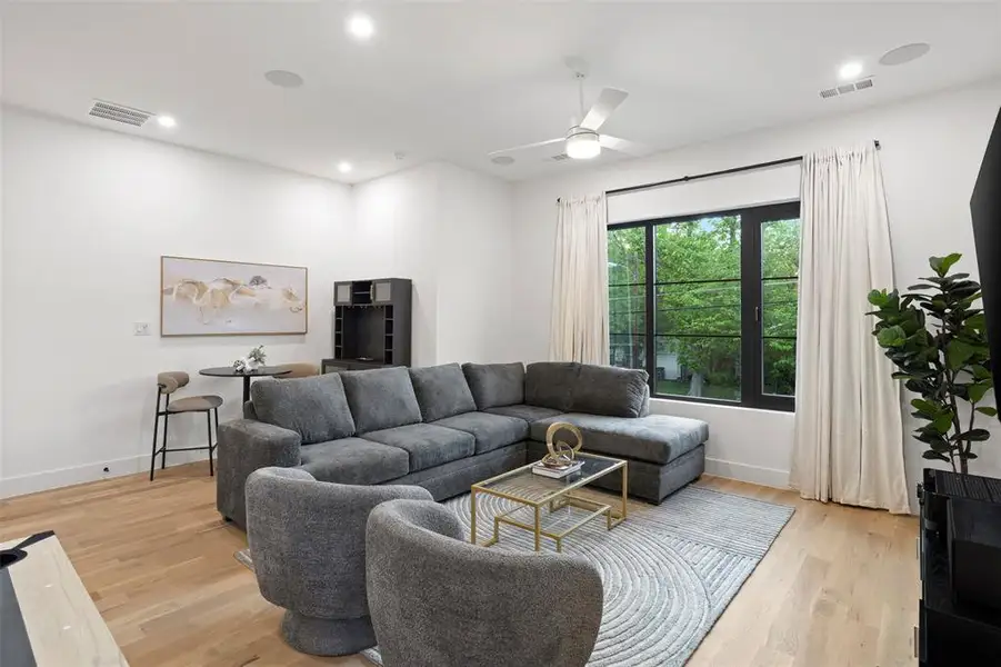 Spacious interior featuring wood-finish flooring, recessed lighting, and a contemporary ceiling fan