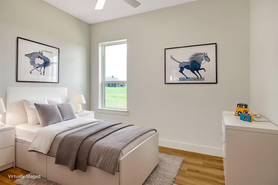 Bright bedroom with wood-finish flooring and a ceiling fan Bright bedroom with wood-finish flooring and a ceiling fan
