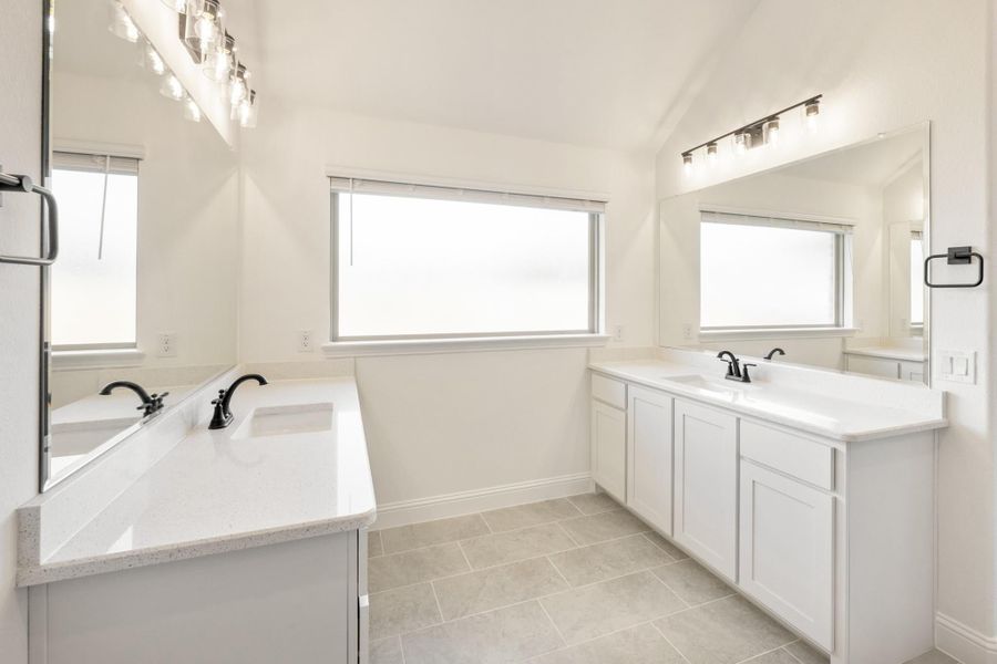 Bathroom with dual vanities, white cabinets, quartz countertops, and tile floors Bathroom with dual vanities, white cabinets, quartz countertops, and tile floors
