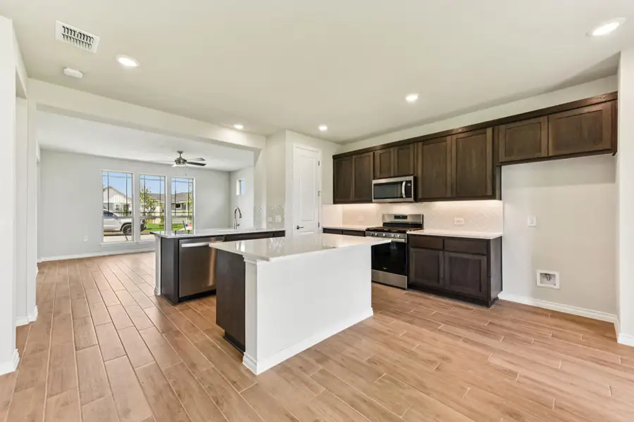 Kitchen featuring a peninsula, stainless steel appliances, recessed lighting, dark brown cabinetry, and decorative backsplash