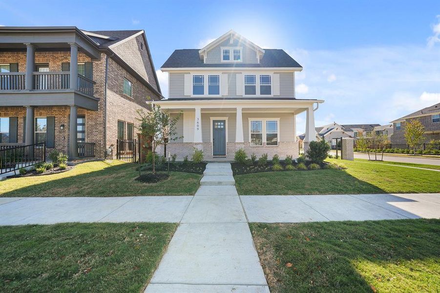 View of front of home featuring covered porch and brick siding