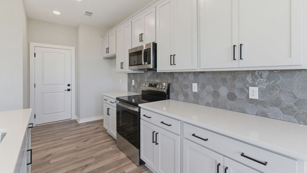 Kitchen with tile backsplash, pendant lighting, and quartz countertops
