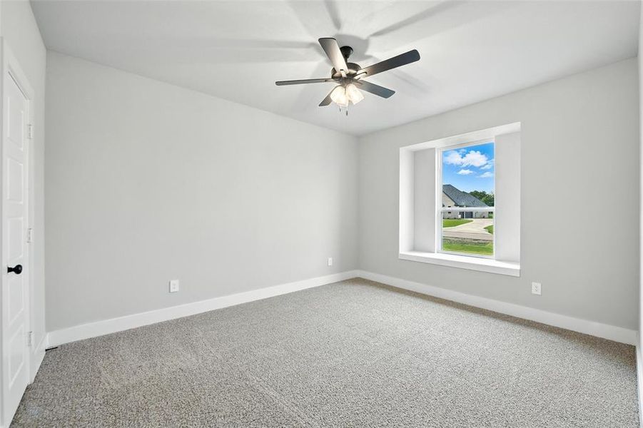 Spare room featuring carpet flooring and a ceiling fan