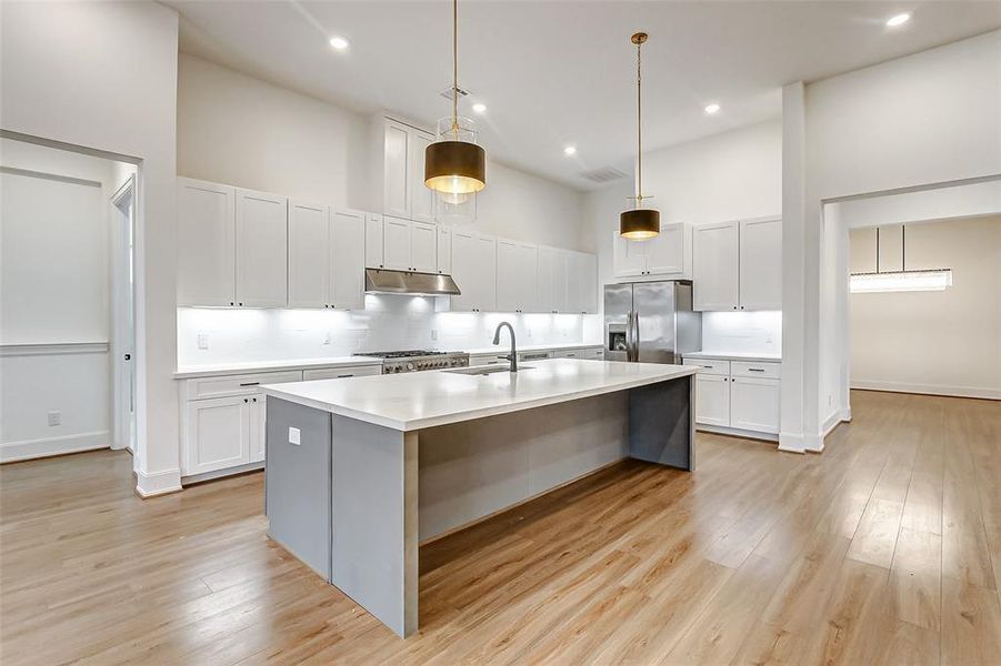 Your chef inspired kitchen awaits! Features include Quartz countertops paired with a coordinating tile backsplash, Stainless Steel appliances, a luxe gas range, upgraded cabinetry, disk lightings, and a spacious island with breakfast bar seating and pendent lights.