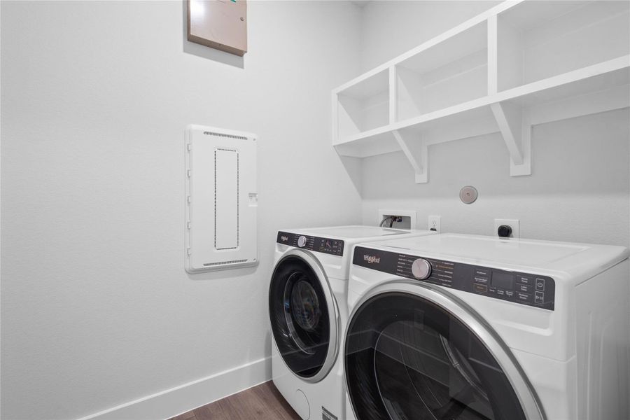 Convenient utility space showcasing Whirlpool front-load washer and dryer appliance set with multi-level shelving above to store your laundry needs. Convenient utility space showcasing Whirlpool front-load washer and dryer appliance set with multi-level shelving above to store your laundry needs.