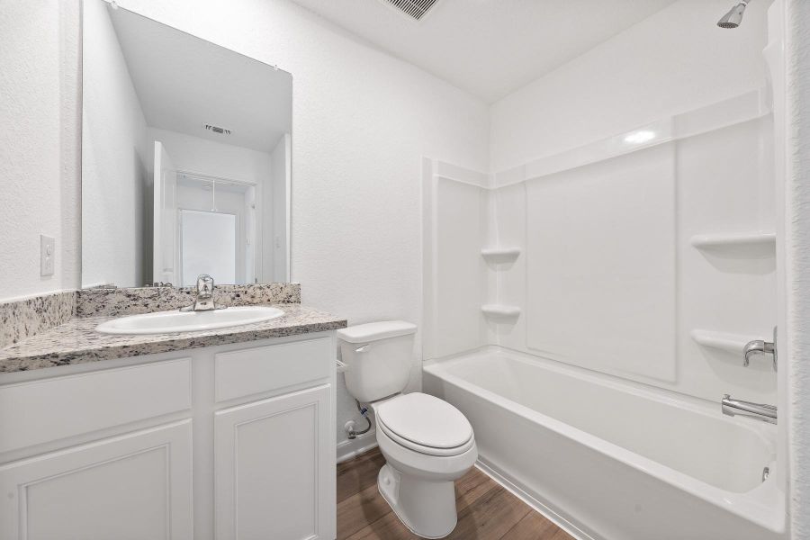 White cabinetry, a polished vanity, and modern fixtures define this functional bathroom.