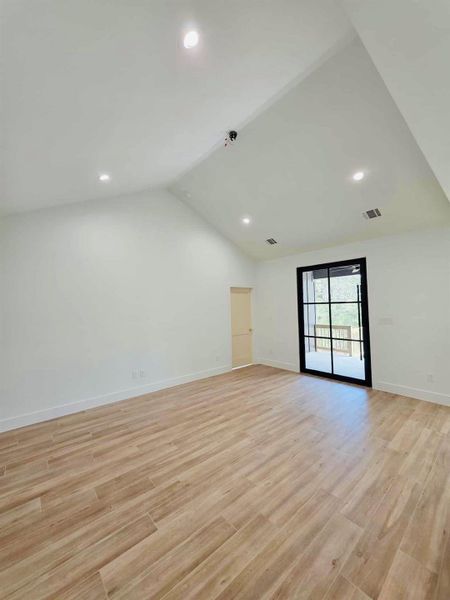 Unfurnished room featuring vaulted ceiling, light wood-style floors, and recessed lighting