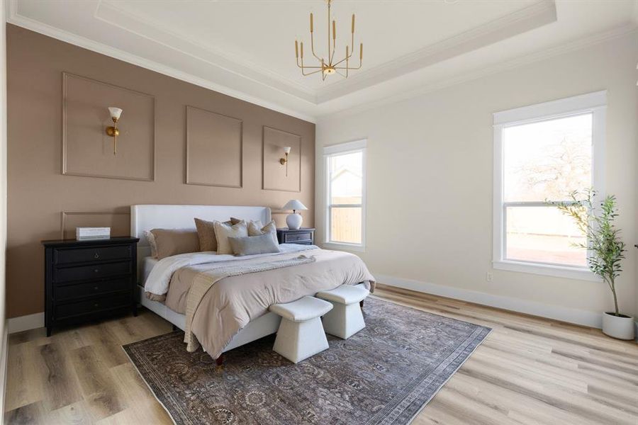 Master Bedroom featuring a chandelier, light wood-type flooring, and a tray ceiling