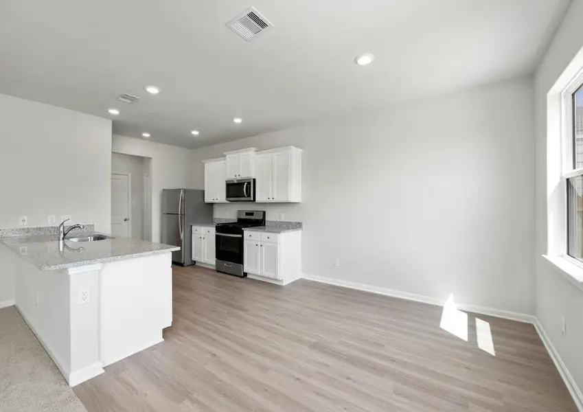 The kitchen is open to the dining room and has plank flooring.