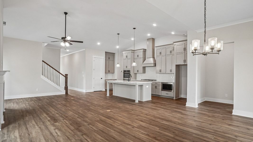 View of living room and kitchen from dining area with vaulted ceilings