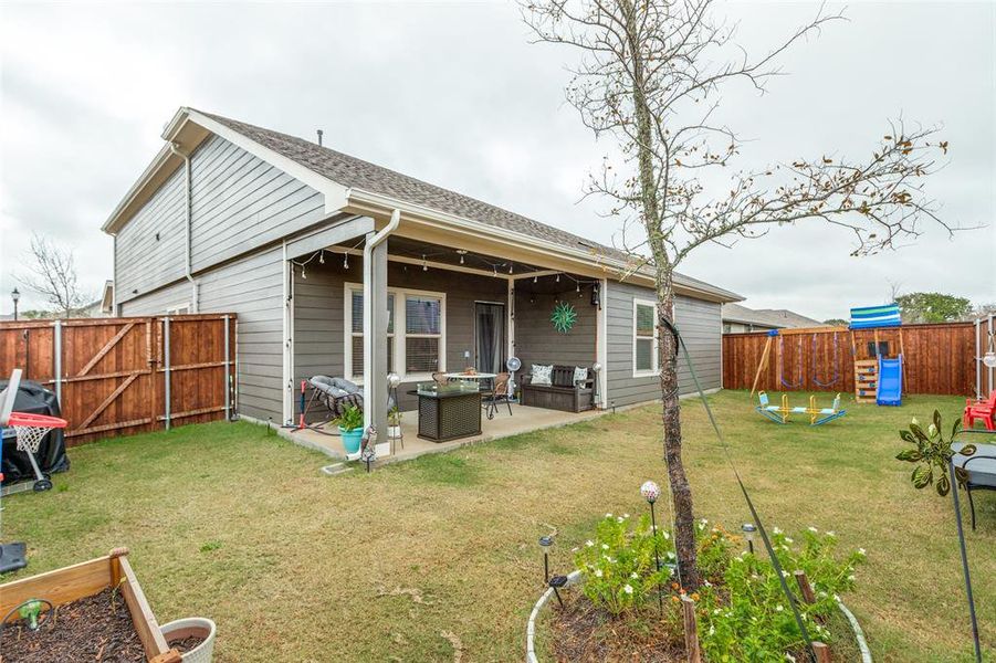 Back of house featuring a fenced backyard, a patio area, a playground, roof with shingles, and a gate Back of house featuring a fenced backyard, a patio area, a playground, roof with shingles, and a gate