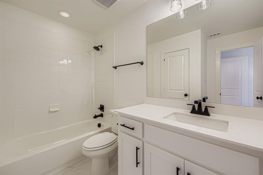 Full bath featuring washtub / shower combination, vanity, and recessed lighting