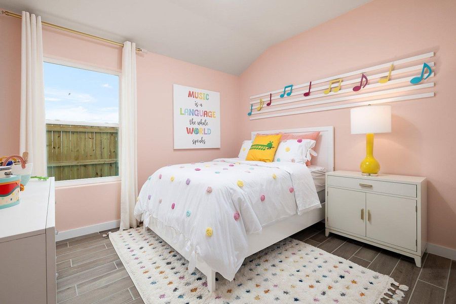 This cozy bedroom features a vaulted ceiling and elegant hardwood flooring, perfect for rest and relaxation.