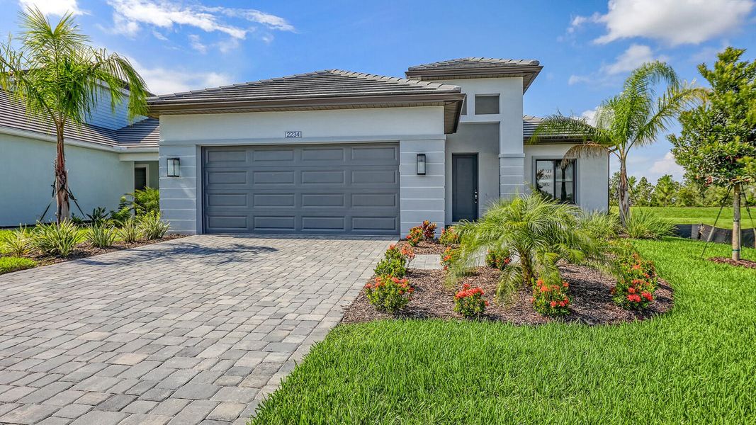 Front exterior of a new home in Palm Grove Real Estate and Homes for Sale in Lakewood Ranch, FL - Neal Communities, Lakewood Ranch, FL, highlighting curb appeal (Image 29).