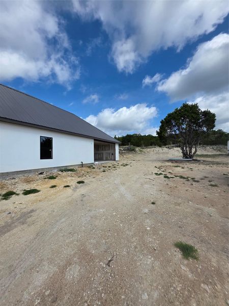 Single-story residence featuring a dark metal roof and white exterior