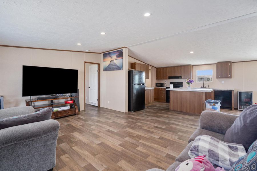 An open floorplan seamlessly connects the living space to a kitchen featuring a functional island.